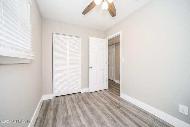 unfurnished bedroom featuring light hardwood / wood-style floors, a closet, and ceiling fan