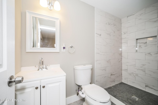 bathroom with vanity, toilet, and a tile shower