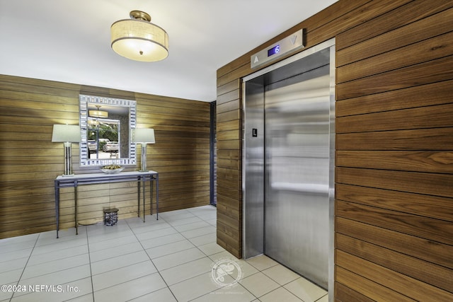 6000 San Jose Blvd Unit 11-C, Jacksonville, FL 32217 - kitchen with light tile patterned flooring, wooden walls, and elevator