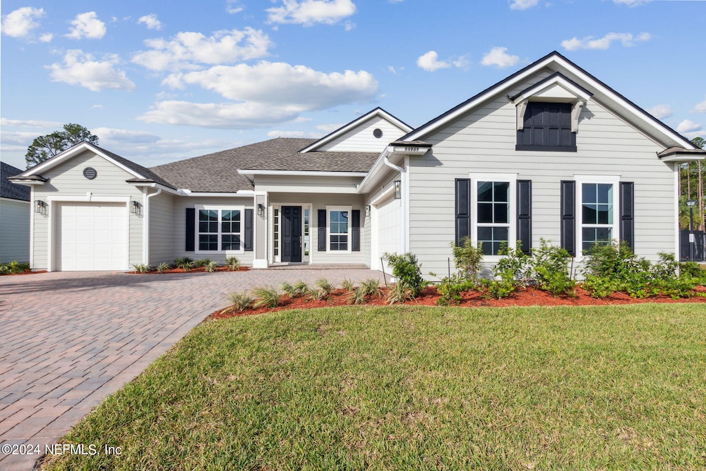 view of front of home with a front lawn and a garage