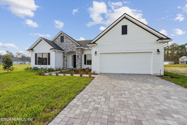 85425 Sandy Ridge Loop Unit 0085, Yulee, FL 32097 - view of front facade with an attached garage, stone siding, a front lawn, and decorative driveway