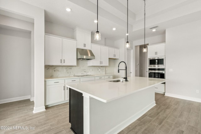 85425 Sandy Ridge Loop Unit 0085, Yulee, FL 32097 - kitchen with light countertops, a kitchen island with sink, a sink, white cabinetry, and under cabinet range hood