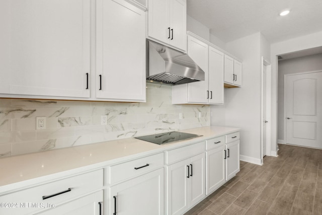 85425 Sandy Ridge Loop Unit 0085, Yulee, FL 32097 - kitchen featuring white cabinets, wall chimney exhaust hood, black electric cooktop, light countertops, and backsplash