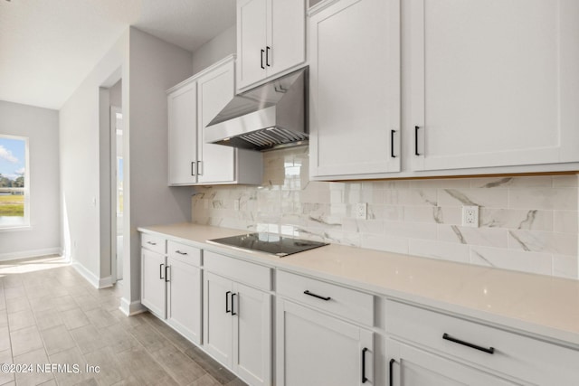 85425 Sandy Ridge Loop Unit 0085, Yulee, FL 32097 - kitchen featuring black electric cooktop, light countertops, under cabinet range hood, white cabinetry, and backsplash