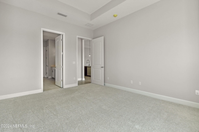 85425 Sandy Ridge Loop Unit 0085, Yulee, FL 32097 - unfurnished bedroom featuring light carpet, baseboards, visible vents, and connected bathroom