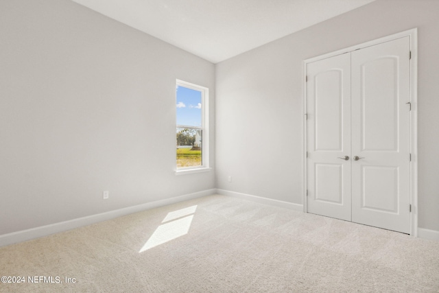 85425 Sandy Ridge Loop Unit 0085, Yulee, FL 32097 - unfurnished bedroom featuring a closet, light carpet, and baseboards