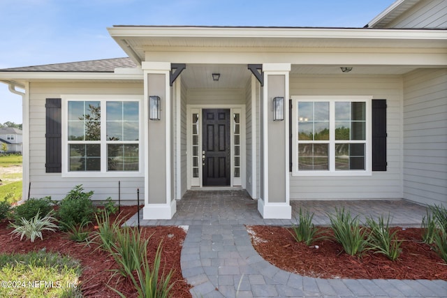 view of exterior entry featuring covered porch