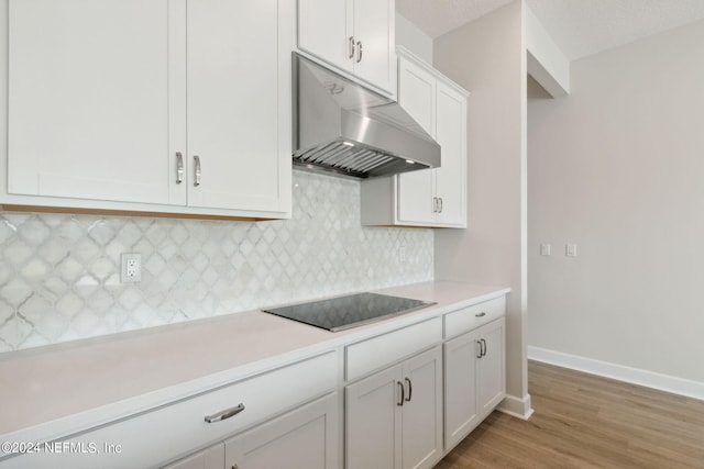 kitchen with wood-type flooring, a textured ceiling, tasteful backsplash, white cabinets, and black electric cooktop