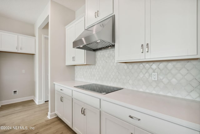 kitchen with black electric cooktop, light hardwood / wood-style flooring, and white cabinets