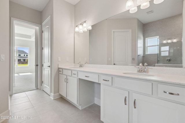 bathroom with tiled shower, vanity, and tile patterned floors