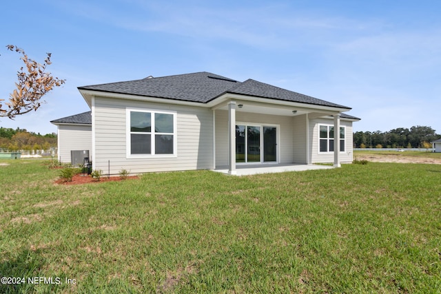 back of house with a lawn, central AC unit, and a patio area