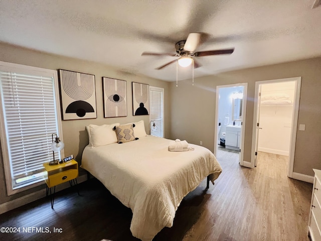 bedroom with a spacious closet, a textured ceiling, and light wood-type flooring