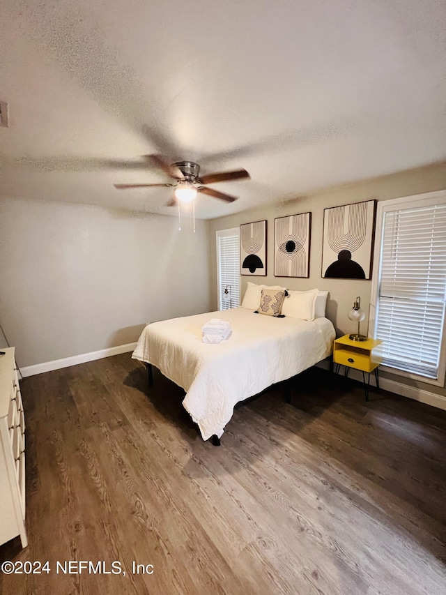 bedroom featuring hardwood / wood-style flooring, ceiling fan, and a textured ceiling