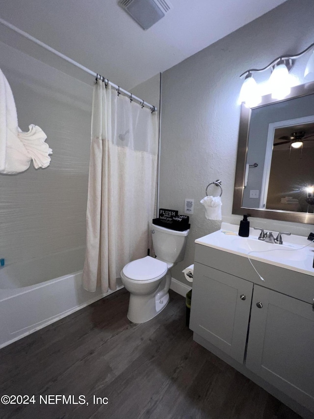 full bathroom with vanity, toilet, hardwood / wood-style floors, and shower / bath combo with shower curtain