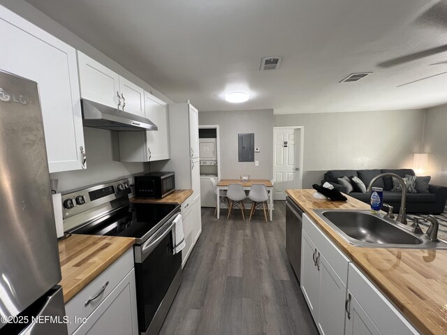 7815 Jasper Ave, Jacksonville, FL 32211 - kitchen featuring a sink, stainless steel appliances, electric panel, under cabinet range hood, and butcher block countertops