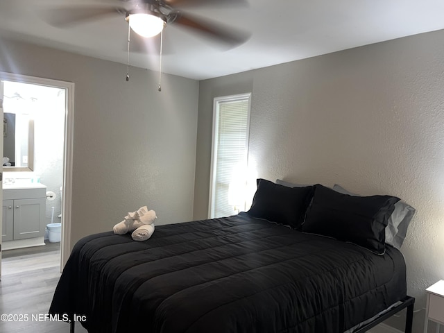 7815 Jasper Ave, Jacksonville, FL 32211 - bedroom with ensuite bath, a textured wall, a ceiling fan, and light wood-style flooring