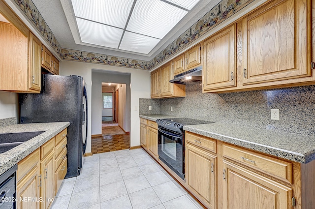 kitchen with light tile patterned flooring, backsplash, sink, and black appliances