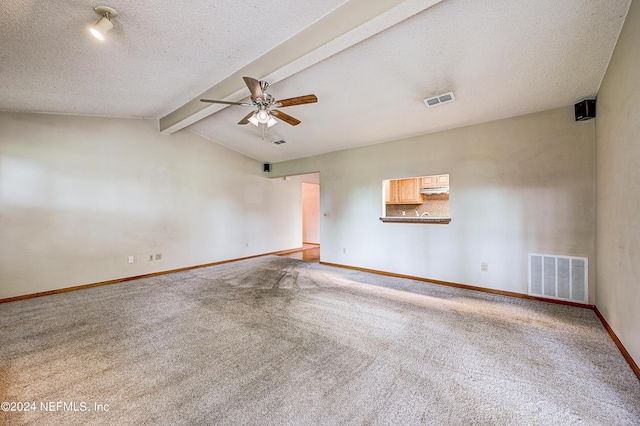 empty room with vaulted ceiling with beams, ceiling fan, carpet floors, and a textured ceiling