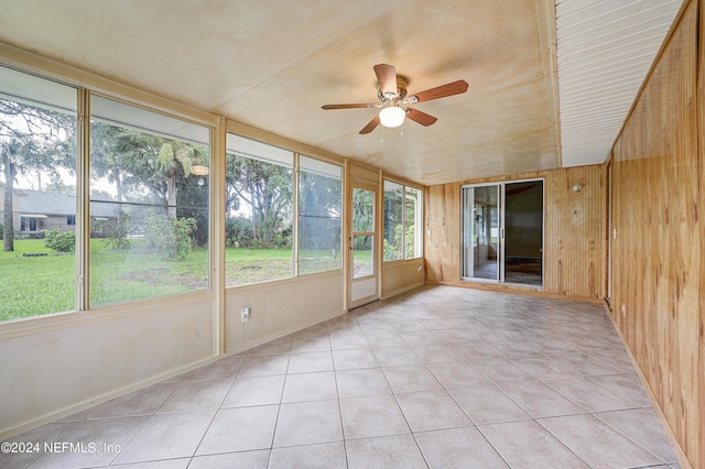 unfurnished sunroom featuring ceiling fan and a healthy amount of sunlight