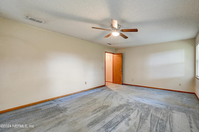 spare room with ceiling fan, light colored carpet, and a textured ceiling