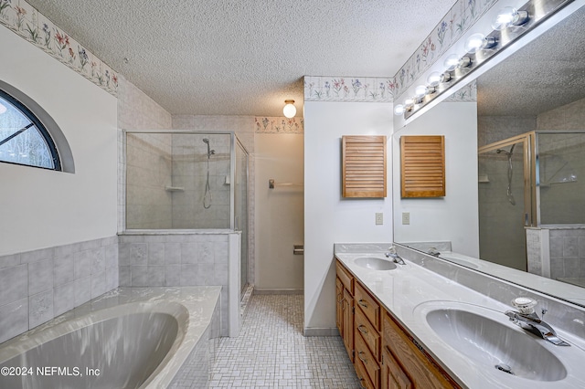 bathroom with tile patterned floors, vanity, a textured ceiling, and independent shower and bath