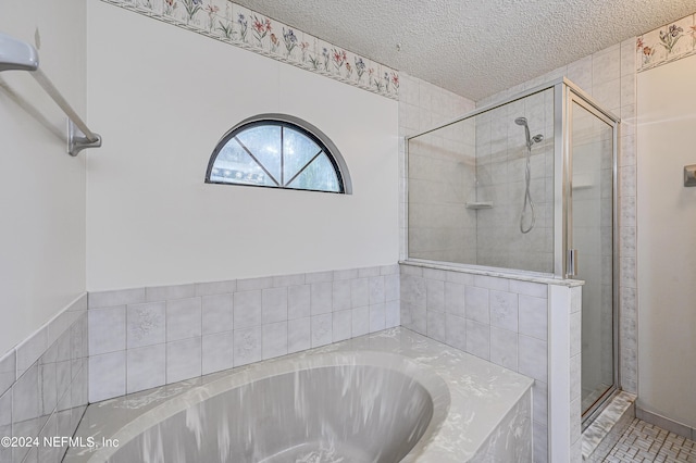 bathroom featuring tile patterned flooring, shower with separate bathtub, and a textured ceiling