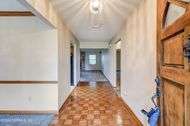 corridor featuring a textured ceiling and light parquet flooring