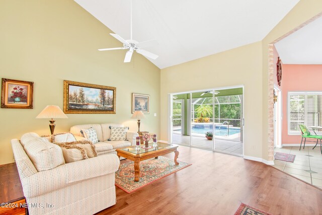 living room with high vaulted ceiling, ceiling fan, and hardwood / wood-style floors