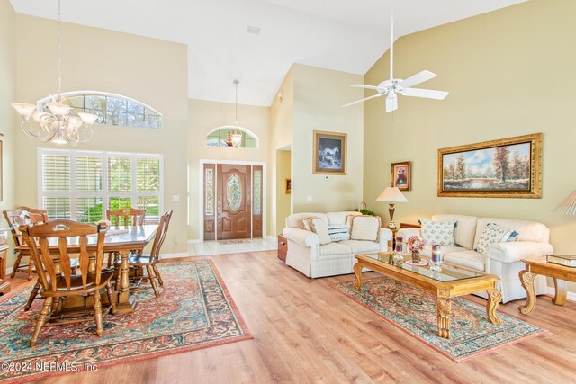 interior space with high vaulted ceiling, ceiling fan with notable chandelier, and hardwood / wood-style flooring