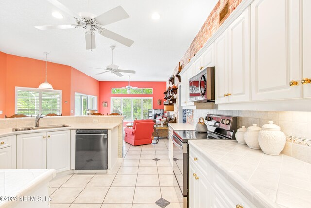 kitchen featuring dishwashing machine, ceiling fan, range with electric cooktop, decorative light fixtures, and sink