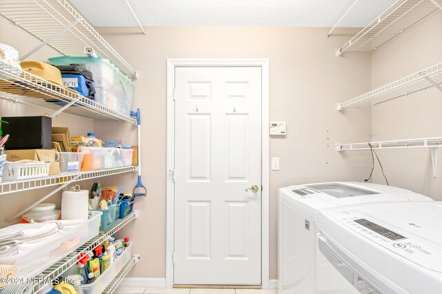 laundry room featuring washing machine and clothes dryer and tile patterned flooring