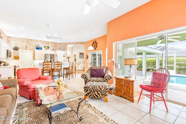 living room with brick wall, light tile patterned floors, and ceiling fan