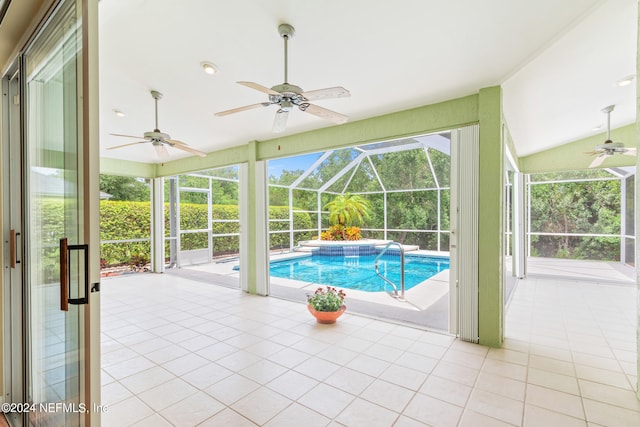 view of pool with a patio, glass enclosure, and ceiling fan