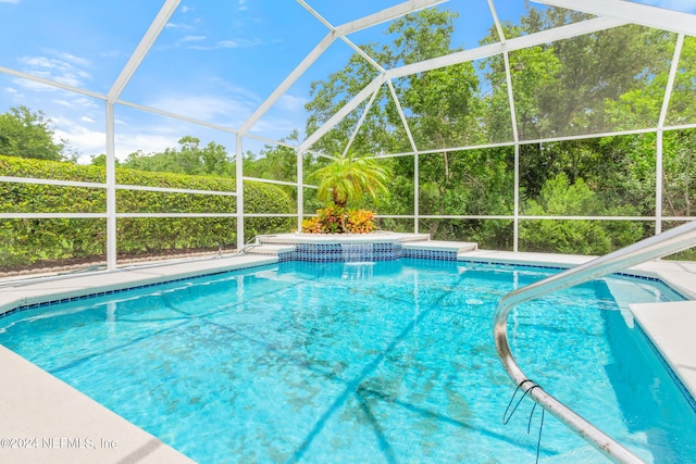 view of swimming pool featuring glass enclosure