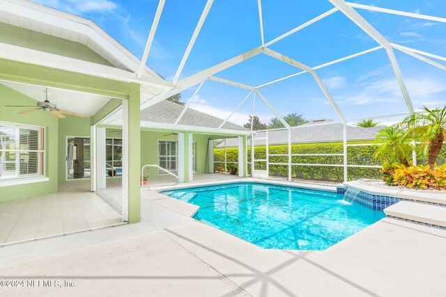 view of swimming pool featuring a patio, pool water feature, a lanai, and ceiling fan