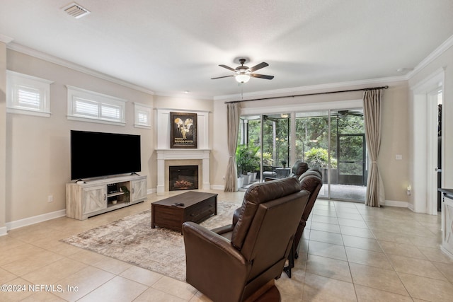 tiled living room featuring a textured ceiling, ceiling fan, and crown molding