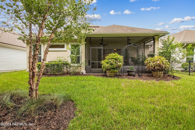 rear view of property with a sunroom, a yard, and ceiling fan