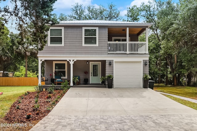 view of front of house featuring a porch, a balcony, fence, driveway, and a front lawn