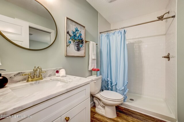 bathroom featuring vanity, walk in shower, wood-type flooring, and toilet