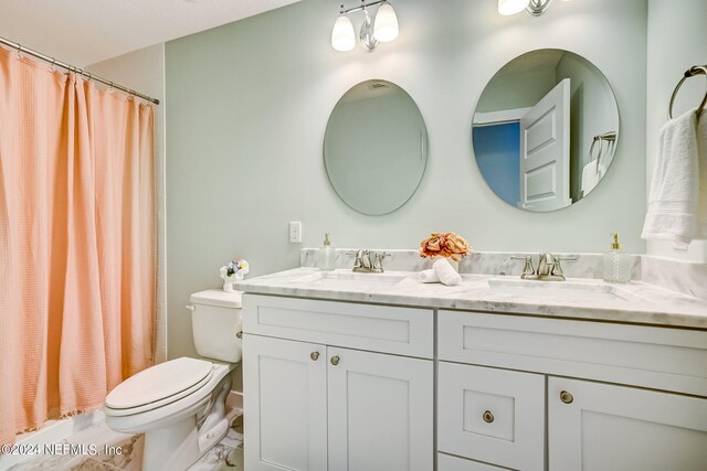 bathroom with double vanity and toilet