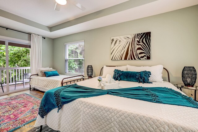 bedroom with access to exterior, hardwood / wood-style floors, and ceiling fan