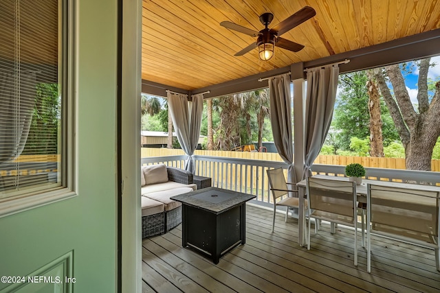 wooden deck with an outdoor living space and ceiling fan