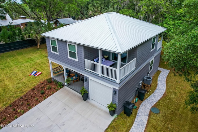 view of front of house with a garage, central air condition unit, and a front yard