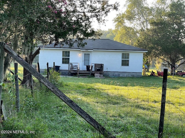 rear view of house with a deck and a yard