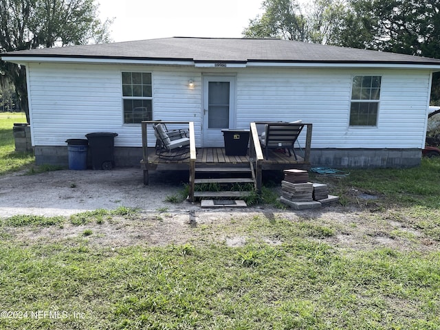 back of property featuring a deck and a yard