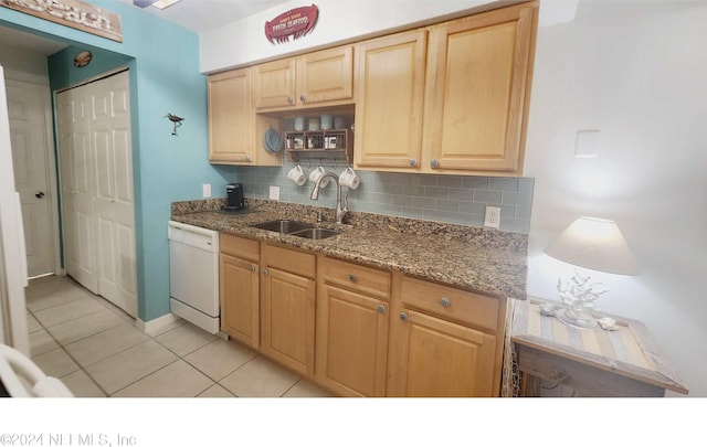 kitchen with light tile patterned floors, dishwasher, backsplash, and sink