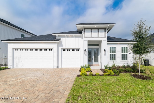 prairie-style home featuring french doors, a garage, and a front lawn