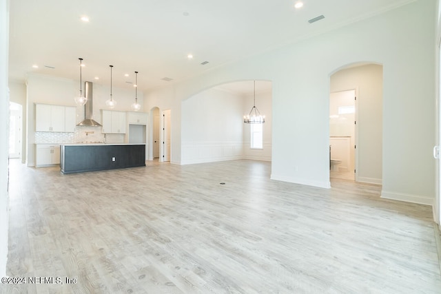 unfurnished living room featuring light hardwood / wood-style floors and a notable chandelier