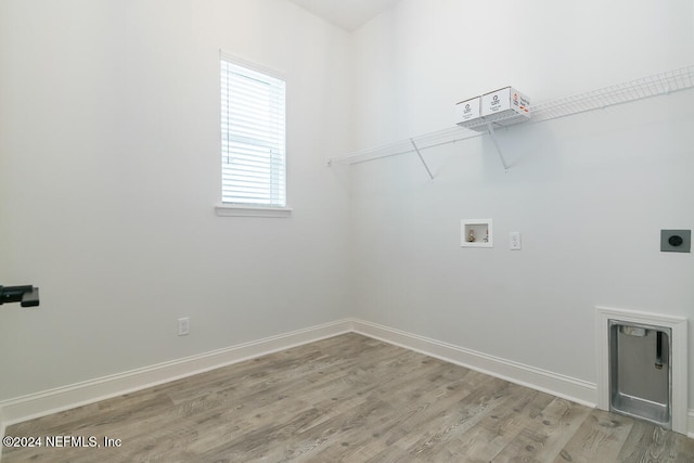 clothes washing area with hookup for an electric dryer, hookup for a washing machine, and light hardwood / wood-style flooring