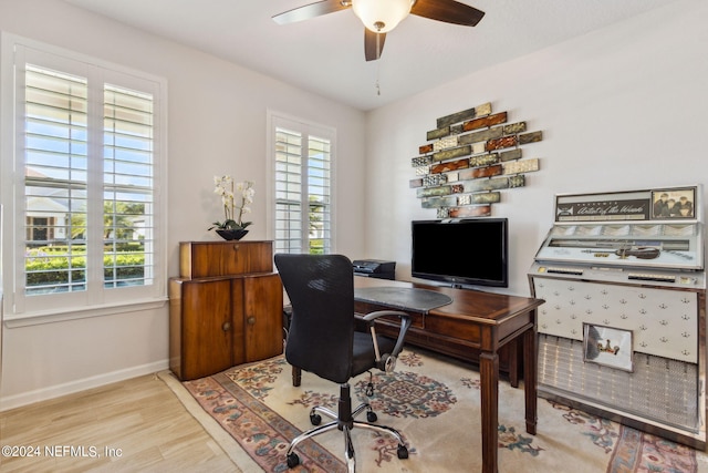 home office featuring light hardwood / wood-style floors, a wealth of natural light, and ceiling fan